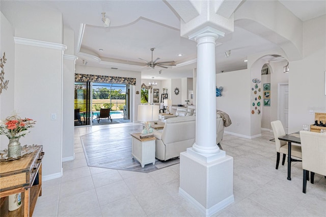 living area featuring light tile patterned floors, decorative columns, arched walkways, and ceiling fan