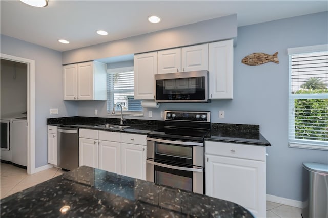 129 Barre Dr NW, Port Charlotte, FL 33952 - kitchen featuring light tile patterned floors, stainless steel appliances, white cabinetry, separate washer and dryer, and a sink