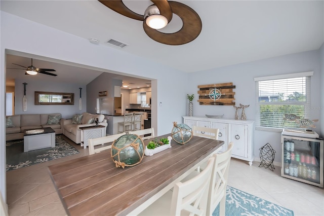 129 Barre Dr NW, Port Charlotte, FL 33952 - dining space with light tile patterned floors, ceiling fan, visible vents, and beverage cooler