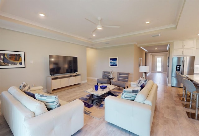 living area with crown molding, recessed lighting, a raised ceiling, a ceiling fan, and baseboards