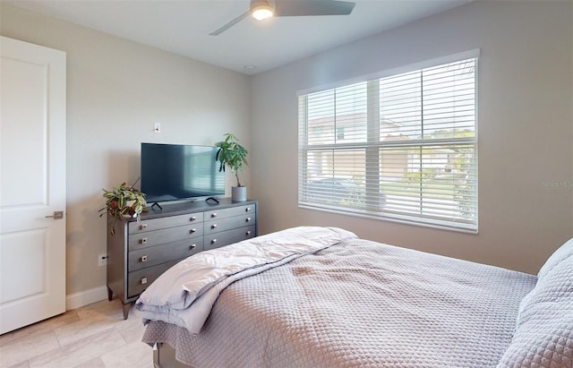 bedroom with baseboards, a ceiling fan, and light tile patterned flooring