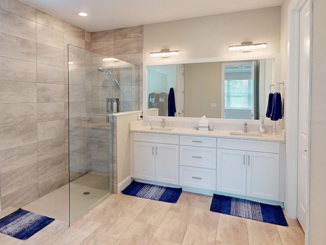 full bathroom with a walk in shower, double vanity, and a sink