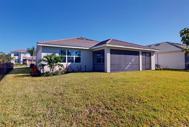 view of front of property featuring a front yard, a sunroom, and stucco siding