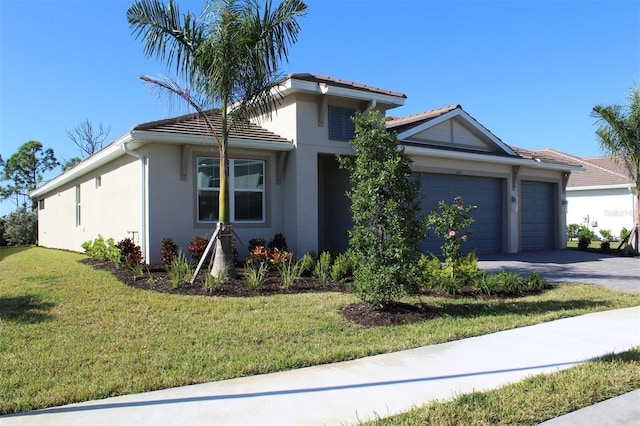 single story home with a garage, driveway, a front lawn, and stucco siding