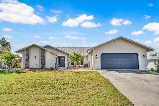 view of front of property with driveway, metal roof, an attached garage, a front lawn, and stucco siding