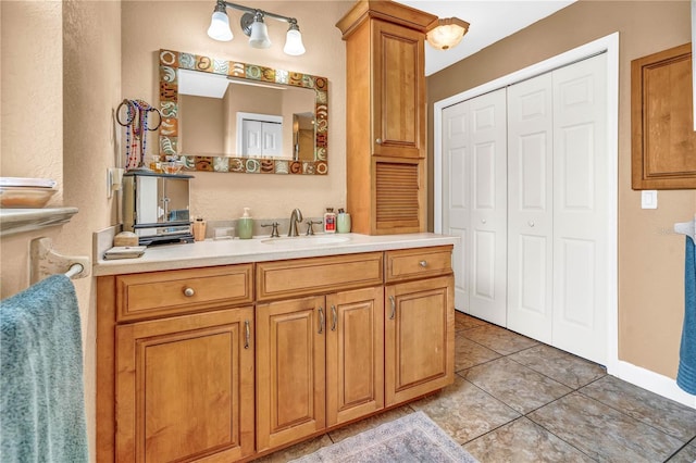 bathroom with vanity, a closet, and tile patterned floors