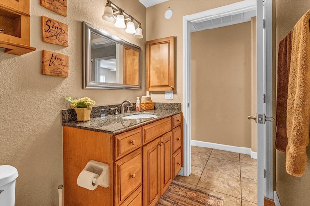 bathroom featuring visible vents, toilet, vanity, tile patterned flooring, and baseboards