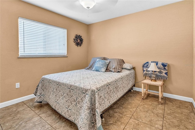 bedroom featuring a ceiling fan, tile patterned flooring, and baseboards