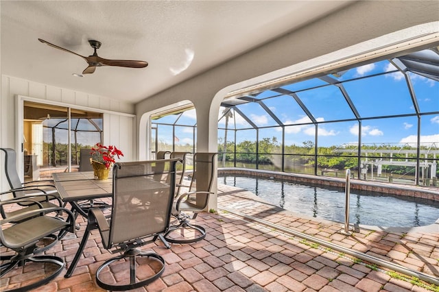 view of patio featuring glass enclosure, ceiling fan, and an outdoor pool