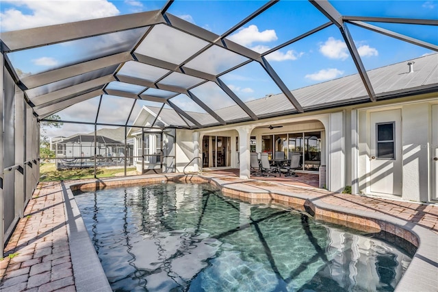 outdoor pool with a lanai, a ceiling fan, and a patio