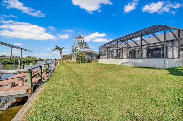 view of yard featuring a dock, a lanai, a water view, and boat lift