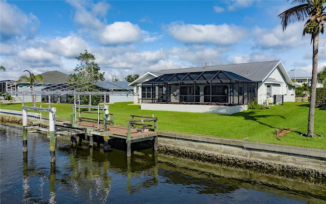 view of dock featuring a lanai, a water view, boat lift, and a lawn