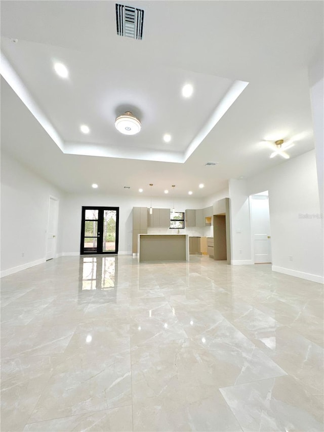 unfurnished living room with french doors, marble finish floor, a raised ceiling, visible vents, and baseboards