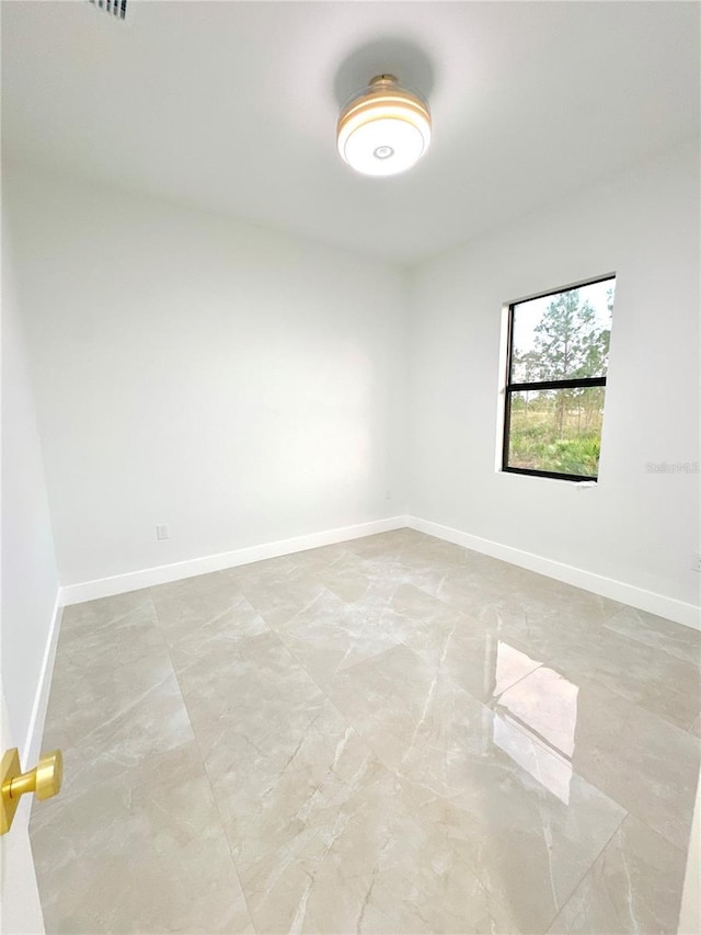 unfurnished room with baseboards