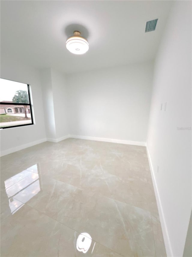 spare room featuring visible vents and baseboards