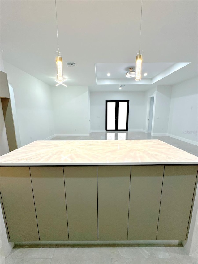 kitchen with pendant lighting, a tray ceiling, visible vents, and green cabinetry