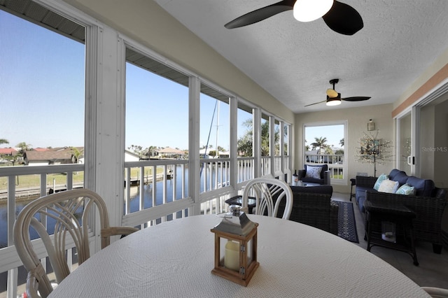 sunroom with a water view and ceiling fan