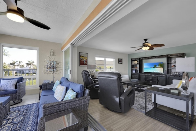 living room featuring a textured ceiling, a ceiling fan, and wood finished floors