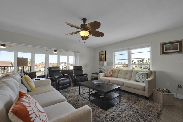 living area with a ceiling fan, baseboards, and wood finished floors