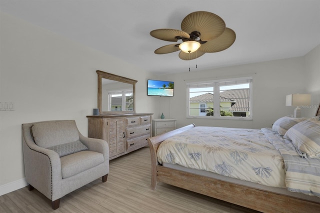 bedroom with light wood-style floors, ceiling fan, and baseboards