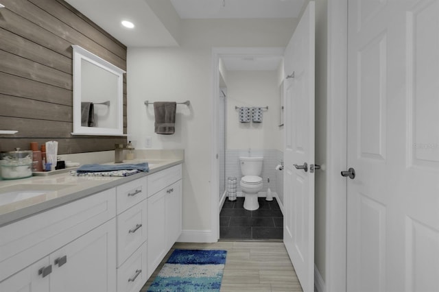 bathroom featuring double vanity, toilet, tile patterned flooring, walk in shower, and a sink