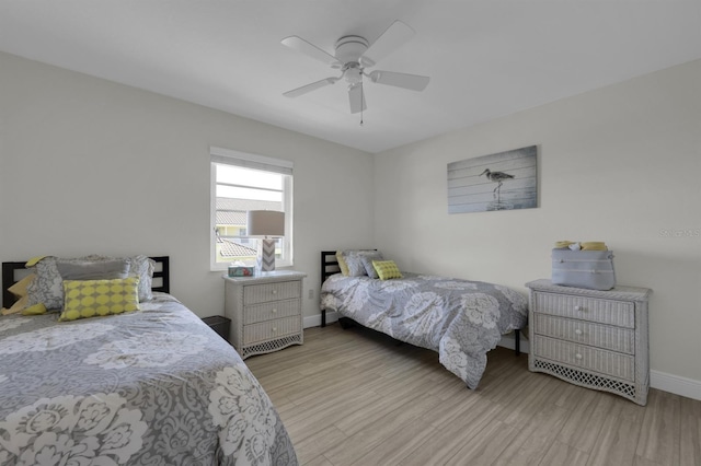 bedroom with wood finished floors, a ceiling fan, and baseboards