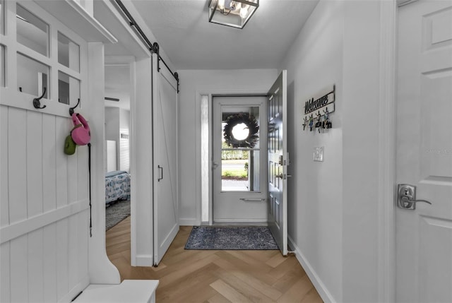 doorway to outside with a barn door and baseboards