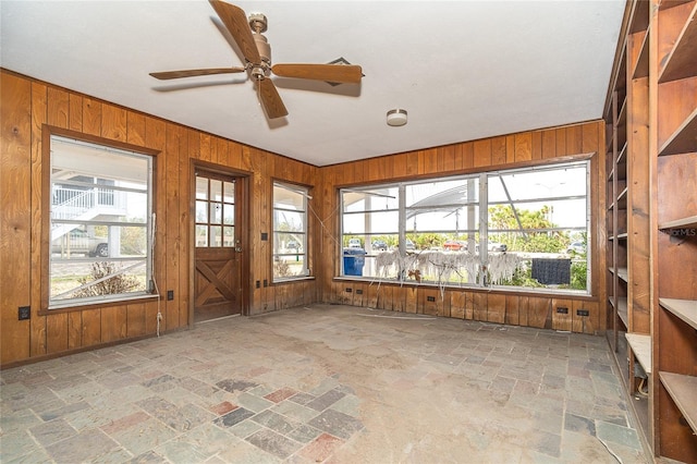 unfurnished sunroom with a ceiling fan