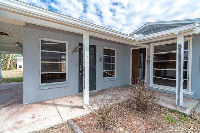 view of exterior entry with stucco siding