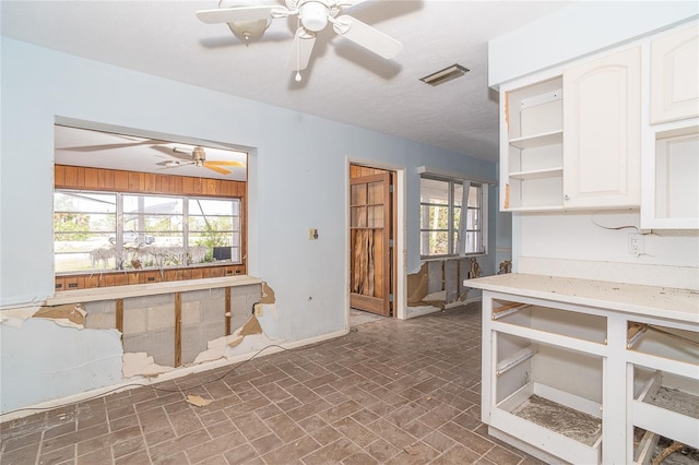 kitchen with visible vents, white cabinets, a ceiling fan, open shelves, and brick patterned floor