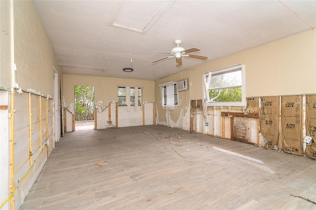 empty room with attic access and a wall mounted air conditioner