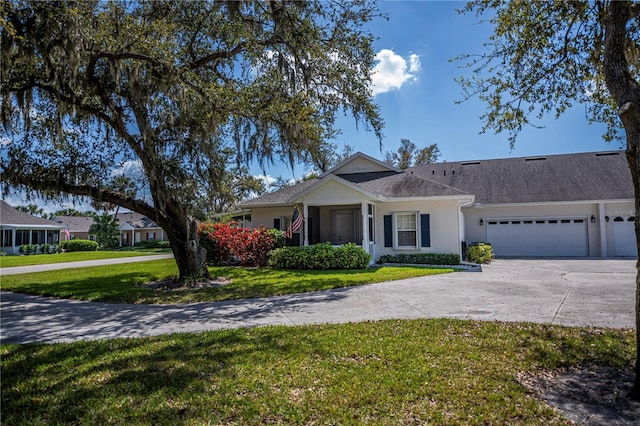 view of front of house featuring an attached garage, concrete driveway, a front yard, and stucco siding