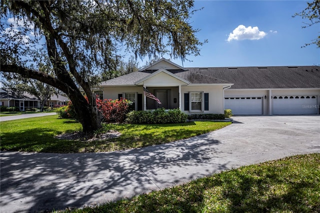 view of front facade with concrete driveway, a front lawn, an attached garage, and stucco siding