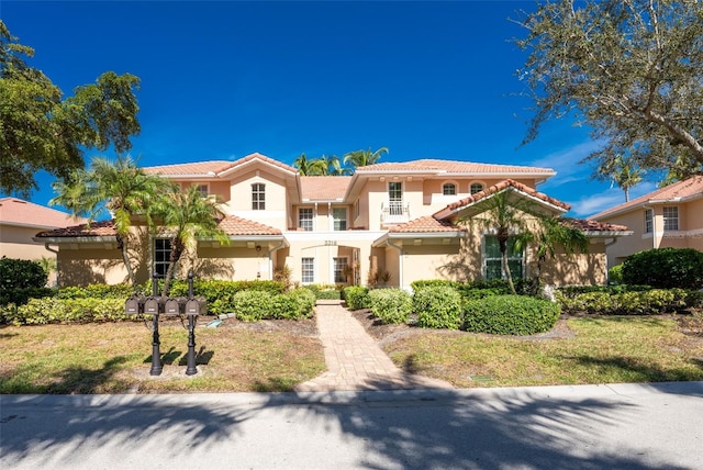 mediterranean / spanish home with a tile roof and stucco siding