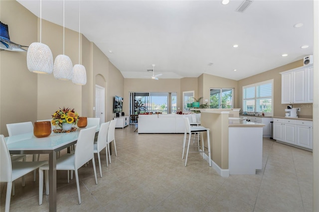 kitchen with light countertops, white cabinets, visible vents, and a kitchen bar