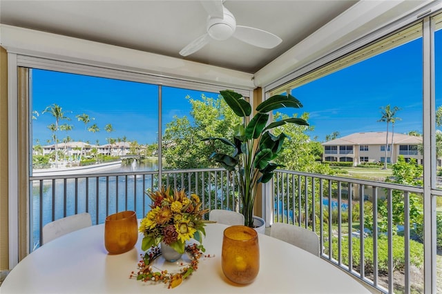 sunroom / solarium with a water view and ceiling fan