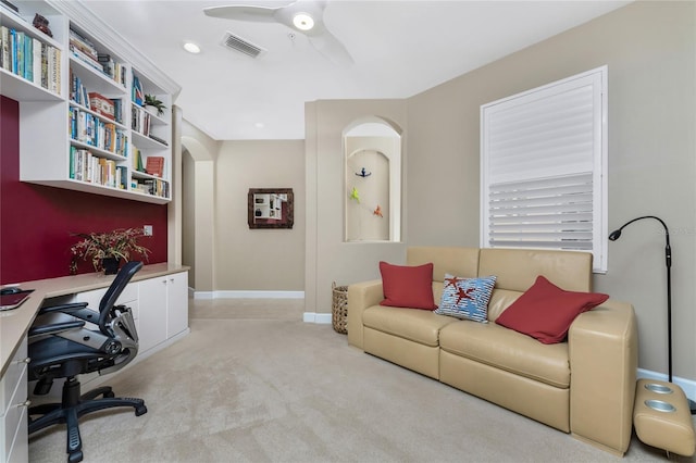 carpeted office with ceiling fan, arched walkways, visible vents, and baseboards