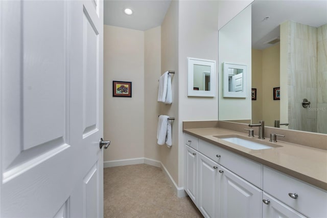 full bathroom with visible vents, vanity, tiled shower, baseboards, and tile patterned floors