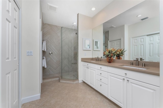 full bathroom featuring visible vents, a sink, a shower stall, and double vanity