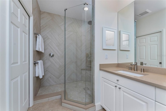 bathroom with a shower stall, visible vents, tile patterned flooring, and vanity