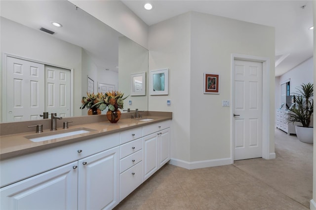 bathroom featuring ensuite bath, a sink, visible vents, and baseboards