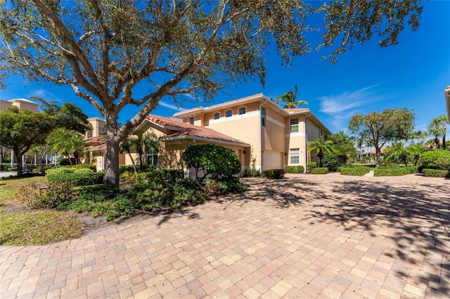 view of side of home with a tile roof and stucco siding