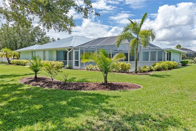 view of home's exterior featuring a lanai, metal roof, and a lawn