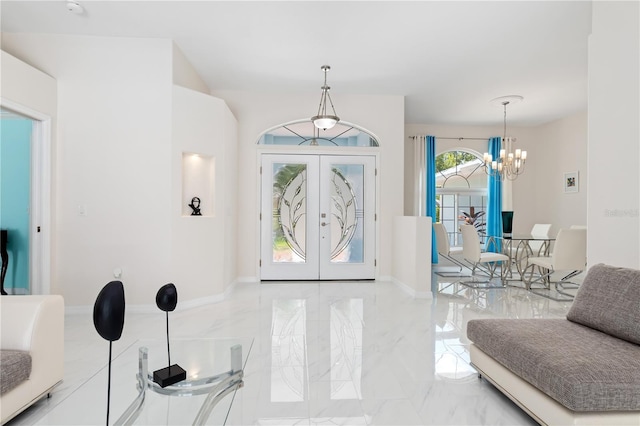 foyer with marble finish floor, baseboards, a notable chandelier, and french doors