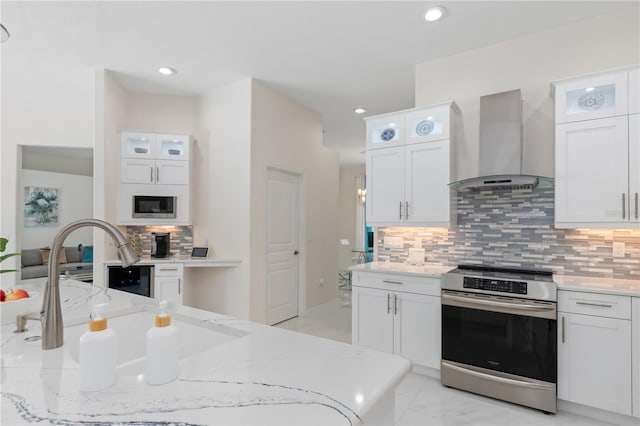 kitchen featuring wall chimney exhaust hood, white cabinetry, and stainless steel appliances