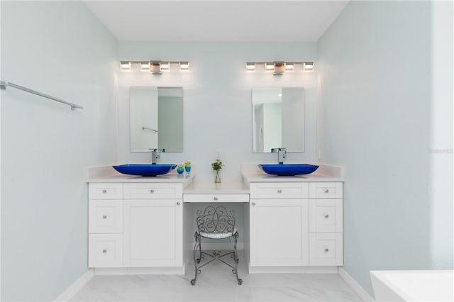 bathroom featuring marble finish floor, vanity, and baseboards