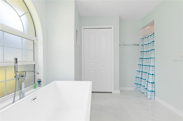 full bathroom with marble finish floor, a shower with curtain, baseboards, and a closet