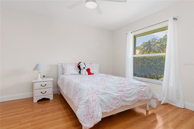 bedroom featuring a ceiling fan, baseboards, and wood finished floors