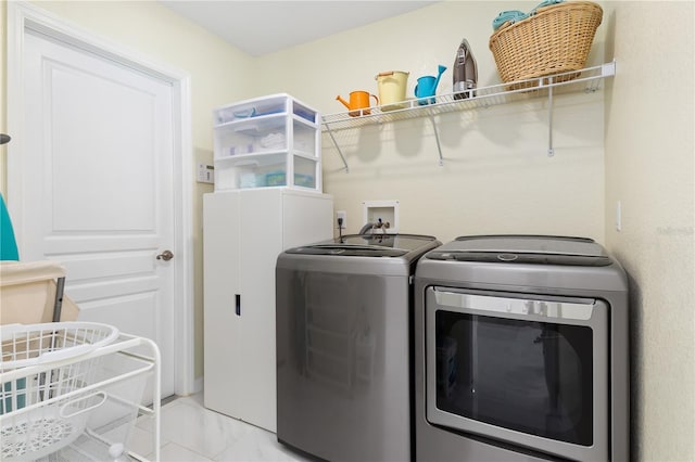 laundry area featuring laundry area, marble finish floor, and separate washer and dryer