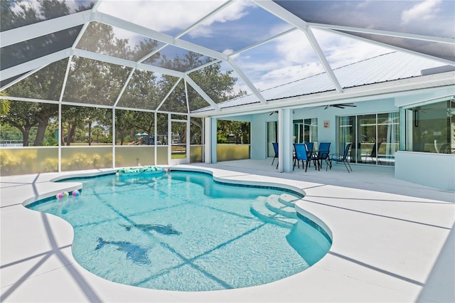 outdoor pool featuring glass enclosure, ceiling fan, and a patio